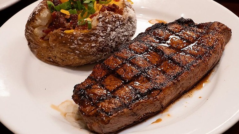 A New York strip steak and baked potato at LongHorn Steakhouse