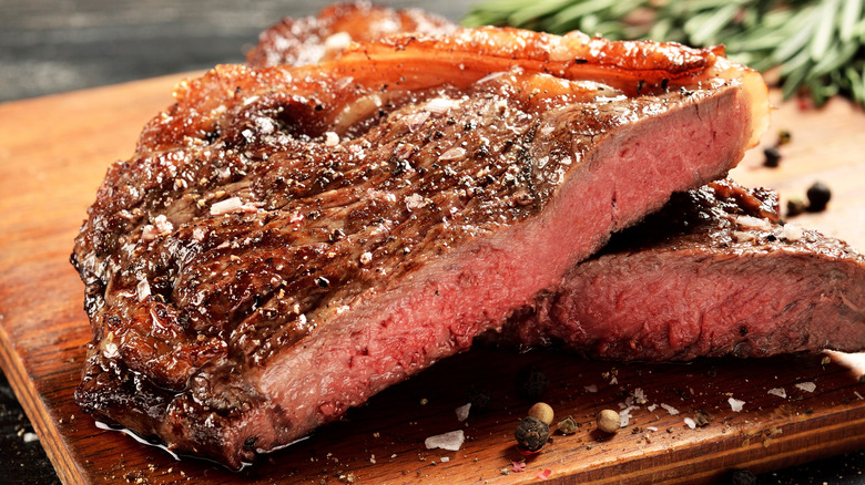 Closeup of a rare New York strip steak on a wooden cutting board