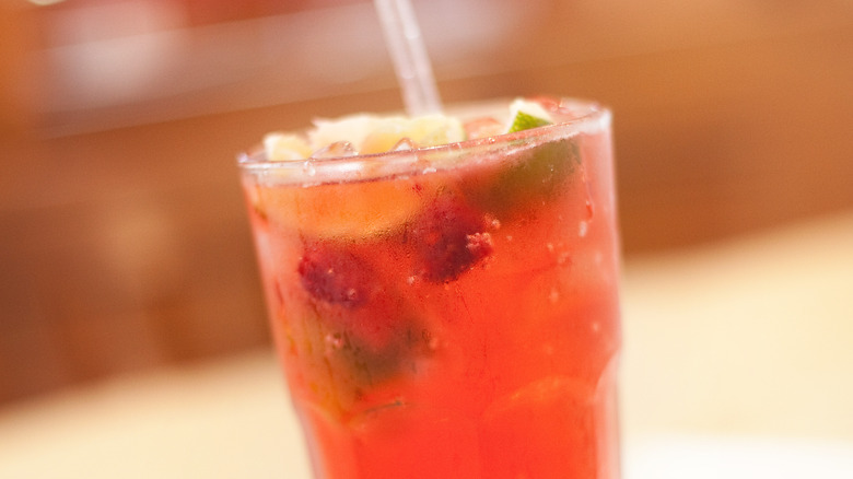 A cherry lime rickey in a glass with a straw