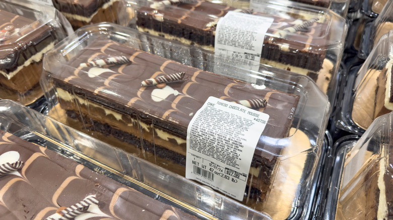 Rows of Tuxedo cakes sit on a table in a Costco bakery