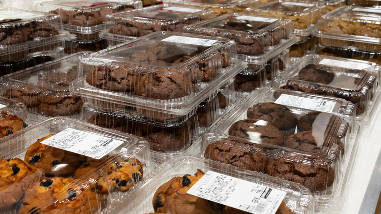Packages of assorted muffins sit on a table in a Costco bakery
