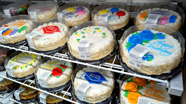 Rows of decorated cakes sit on shelves in a Costco bakery