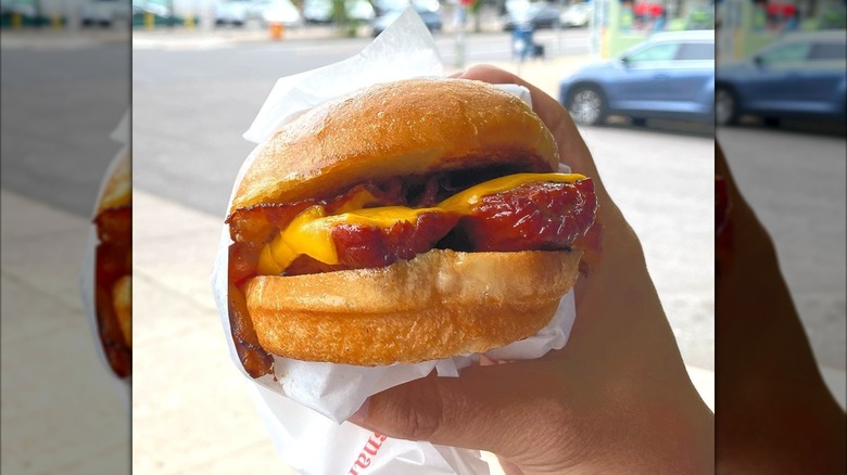 A hot dog sandwich with cheese and bacon