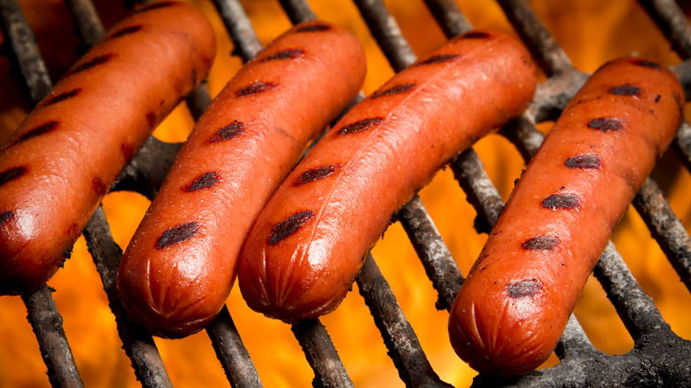 Charred hot dogs on a barbecue grill