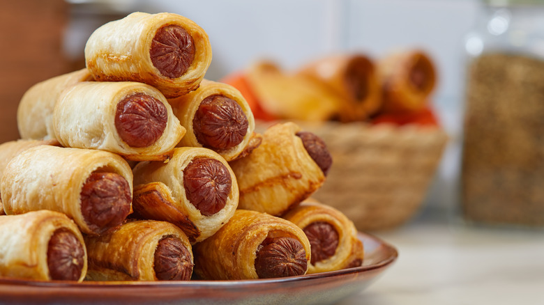Hot dogs wrapped in dough and stacked on a plate