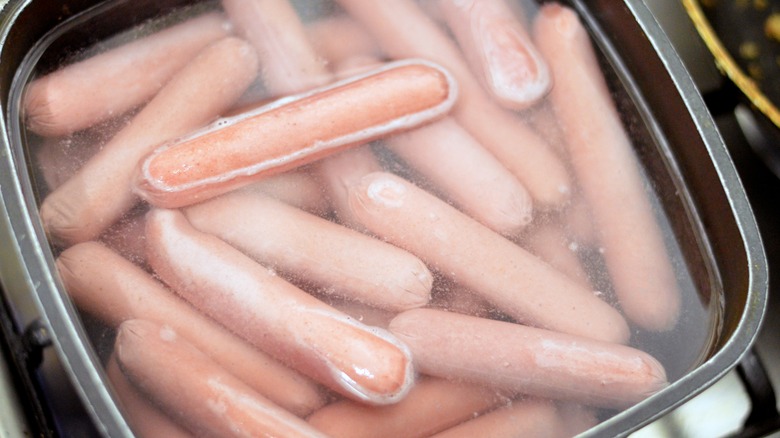 Boiled hot dogs in square pan on stove