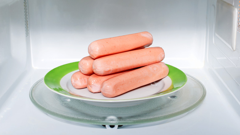 Pyramid of hot dogs on a plate in a microwave