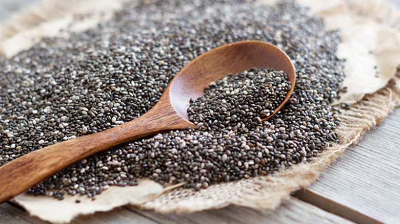 Chia seeds on a cloth with a wooden spoon.