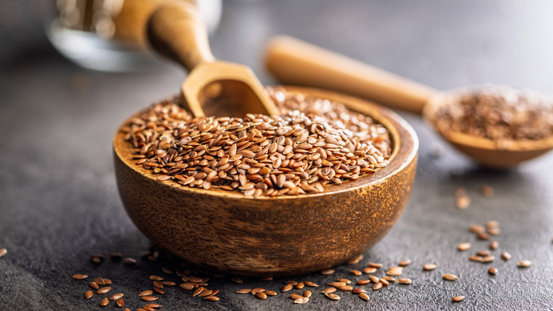 A wooden bowl of flax seeds.