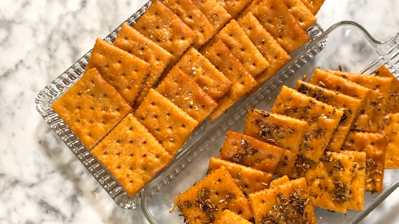 Two plates of buttered saltine crackers.