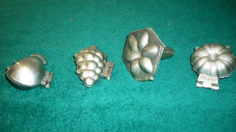 Silver butter molds on green felt