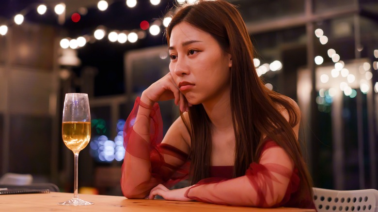 sad woman with glass of wine