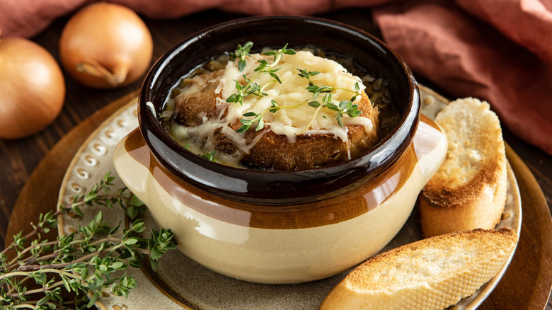 A bowl of French onion soup with slices of bread