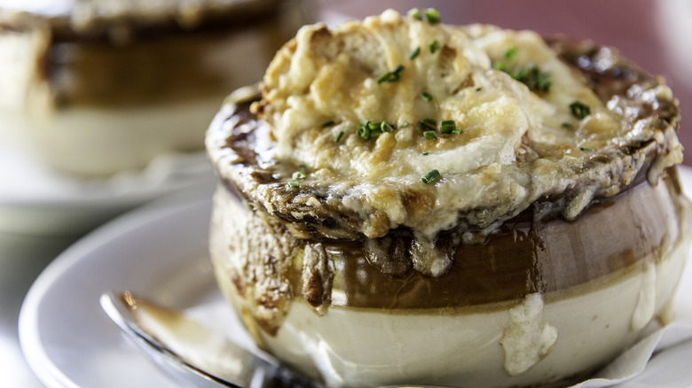 A crock of French onion soup on a plate