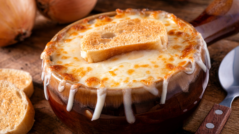 A bowl of French onion soup topped with melted, golden cheese