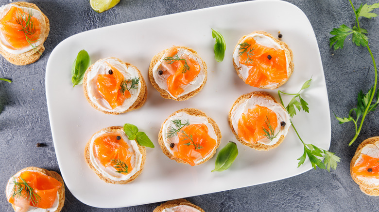 A plate of smoked salmon, dill, and cream cheese canapés