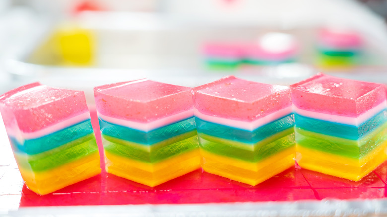 Four rainbow gelatin cubes lined up in a row