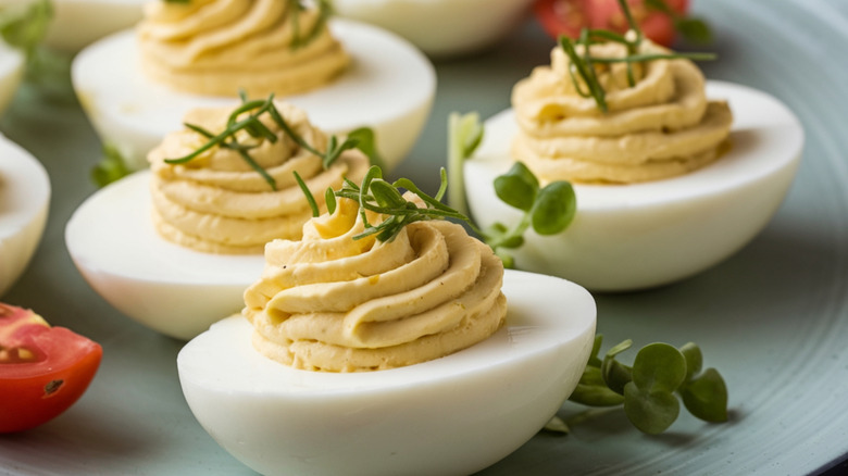 A plate of deviled eggs with chive garnish