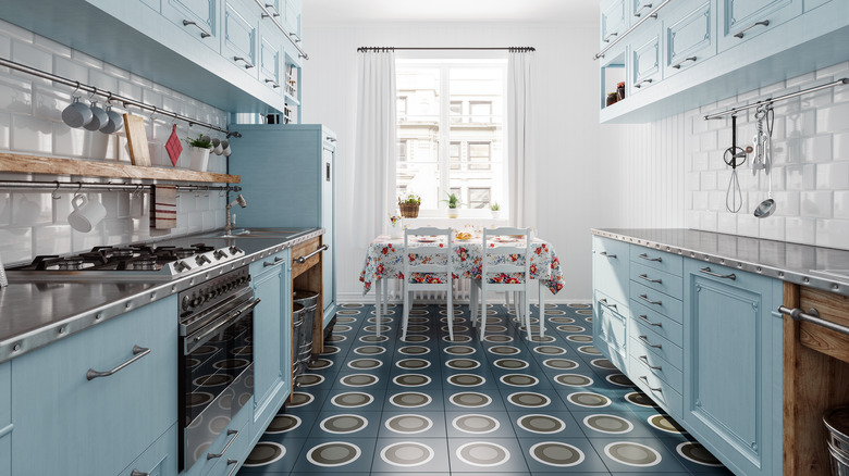 A retro kitchen with blue cabinets and stainless steel counters