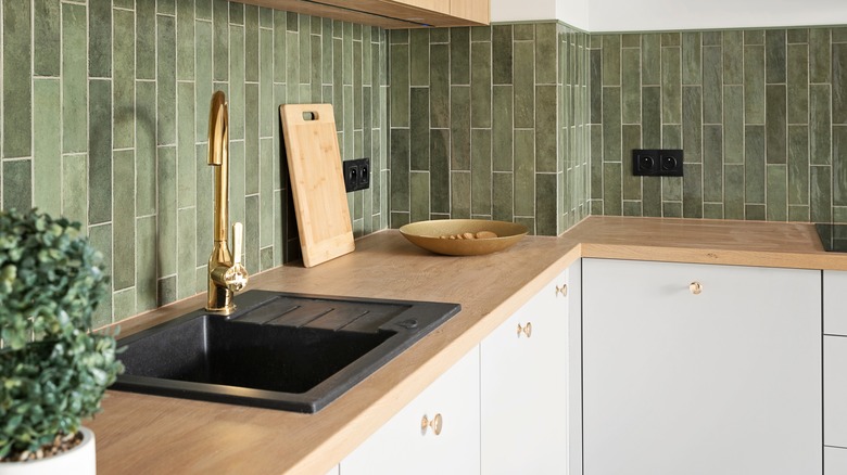 Wood countertop and green tile backsplash
