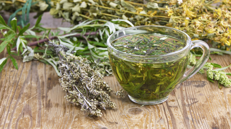 Wormwood stems and tea on wooden table