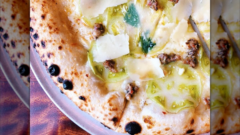 Green tomato pizza with shaved parmesan cheese