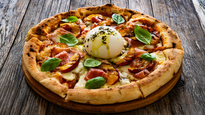 Peach pizza with prosciutto, buratta, and basil