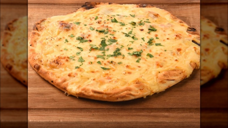 A pizza doused with hot white queso