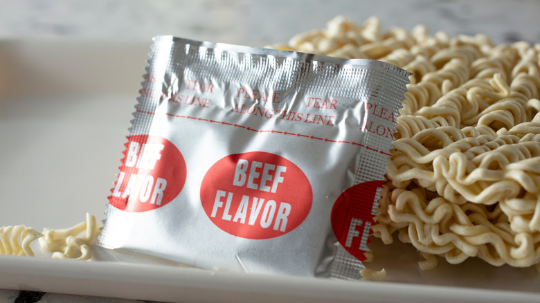 A beef ramen flavor packet next to noodles
