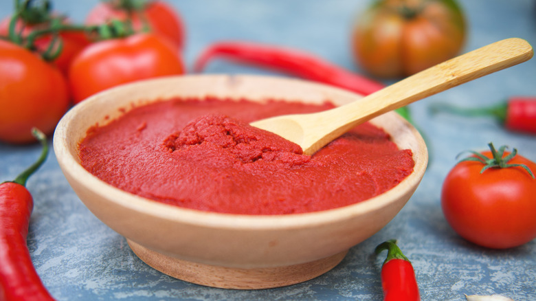 bowl of tomato paste with spoon sticking out