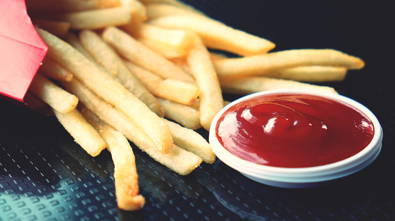 small dish of ketchup next to pile of fries