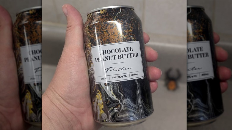 Hand holding a can of chocolate peanut butter porter from Aldi