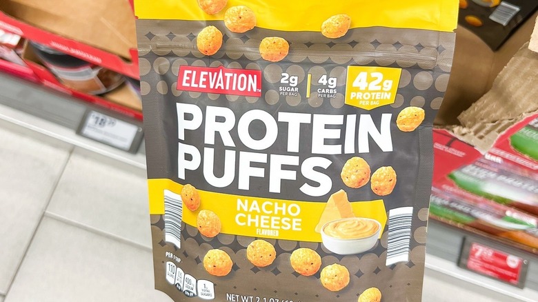 person holding a bag of protein puffs