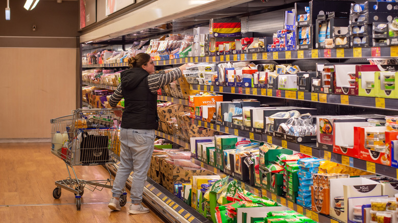 A customer goes through packaged goods at Aldi