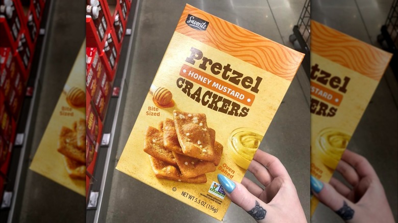 person holding a box of honey mustard pretzel crackers