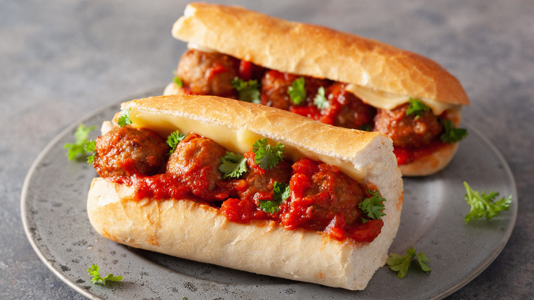 Two meatball subs sit on a gray plate