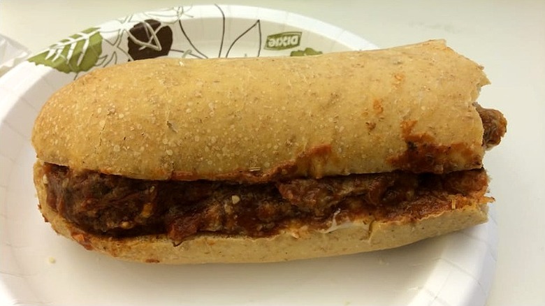 A half meatball sub sits on a paper plate at Lenny's Grill & Subs