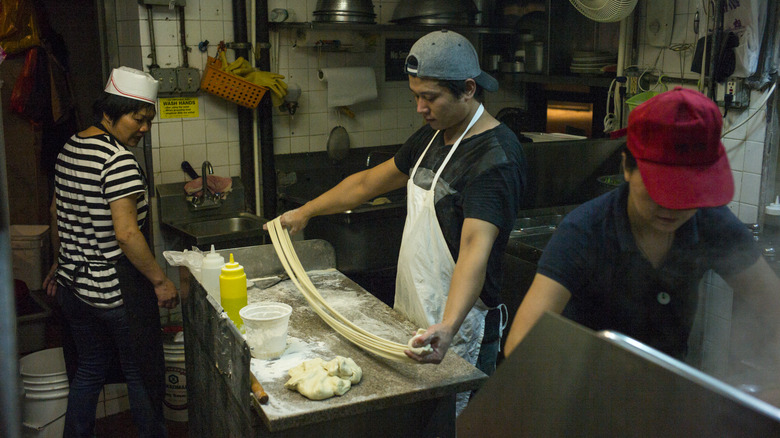 Man pulling noodles in a noodle shop