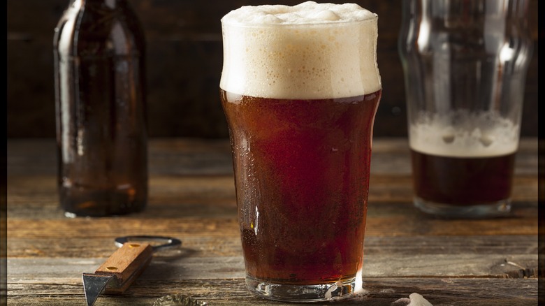Brown ale in glass with large foam head
