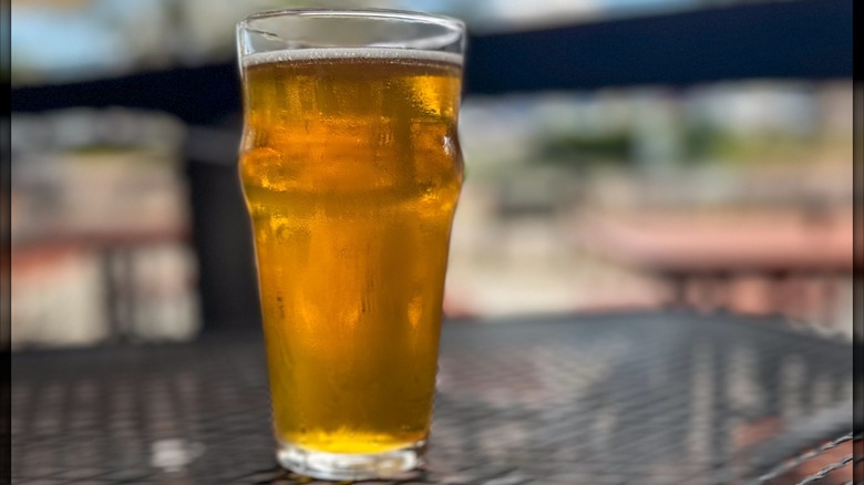 A glass of pale ale on an outdoor patio table