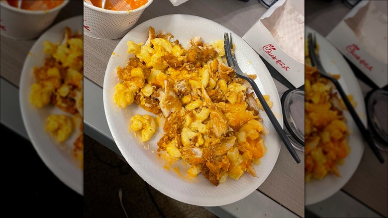 A white plate of Chick-fil-A mac and cheese with chicken and buffalo sauce