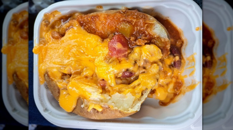 A Chili Baked Potato from Wendy's in a plastic to-go container