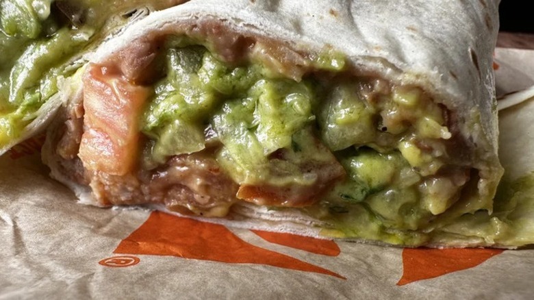 An Incredible Hulk burrito from Taco Bell lies on a paper wrapper