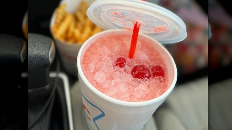 A Sonic cherry vanilla sprite sits in a car's cup holder