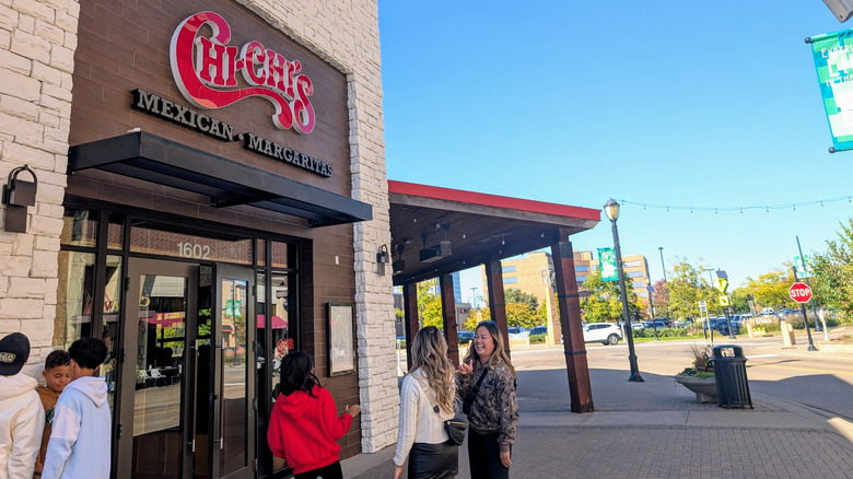 Customers wait outside a Chi Chi's restaurant.
