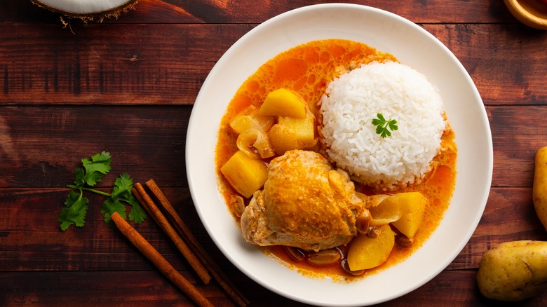 Massaman curry with rice on a wooden table