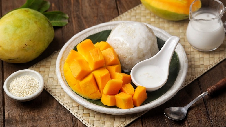 Mango sticky rice on a plate with a bamboo mat