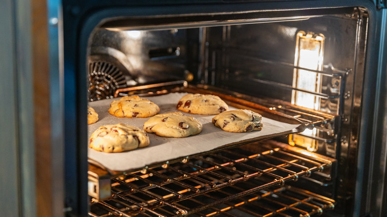 Chocolate chip cookies on parchment paper in an oven