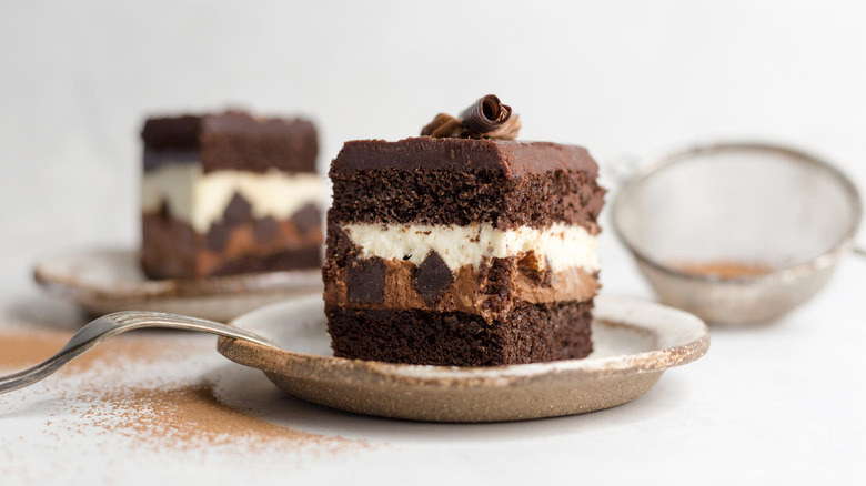 A slice of Costco Tuxedo Cake sits on a small plate on a white table