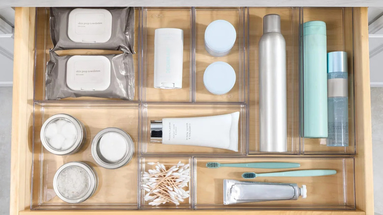 Clear drawer organizers filled with neatly arranged bathroom toiletries.